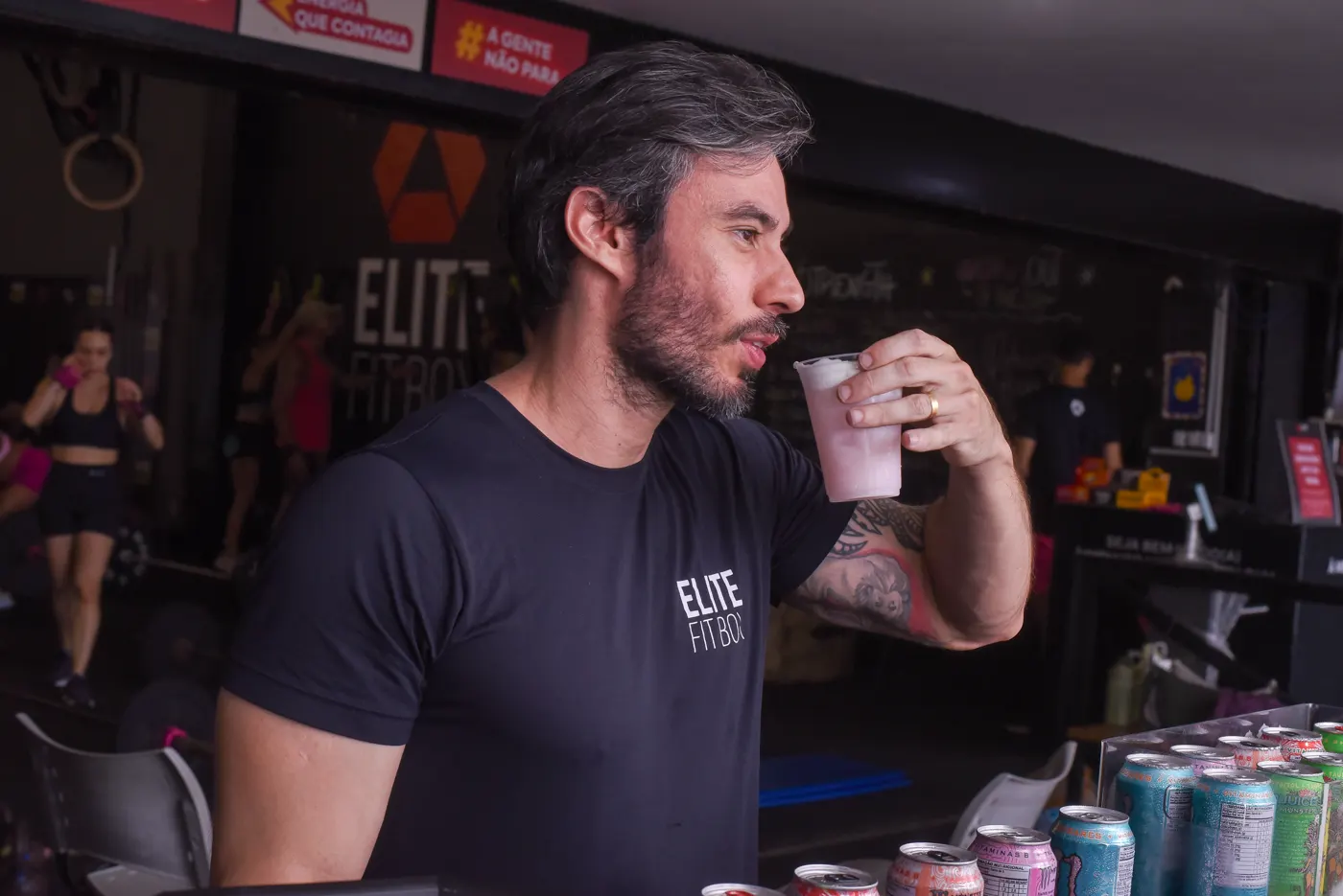 Professor da Elite tomando um suco no espaço de convivência
